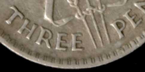 Curvature on the tops of the letters on a 1938 threepence.